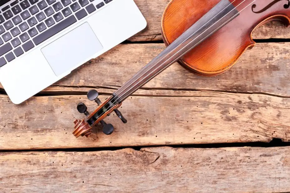 Foto que describe un violín y un ordenador encima de una mesa. 5 consejos para tus clases de música online